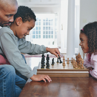 Father playing chess with kids